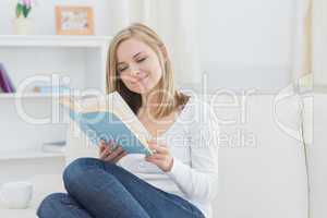 Happy woman reading storybook at home