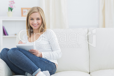 Portrait of happy young woman with notepad at home