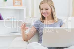 Casual young woman doing online shopping at home