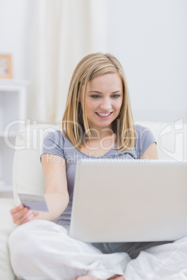 Casual young woman doing online shopping at home