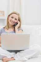 Portrait of casual woman using laptop and cellphone at home