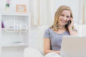 Portrait of woman using laptop and cellphone at home