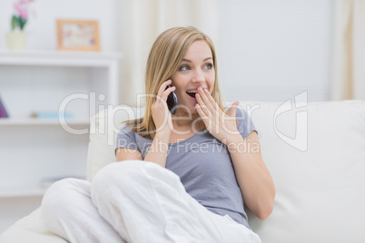 Casual surprised woman using cellphone at home