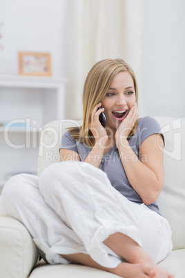 Casual surprised woman using cellphone at home