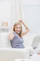 Portrait of excited casual woman with laptop at home