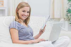 Casual woman with laptop and book in living room