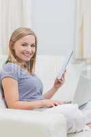 Casual woman with laptop and book in living room