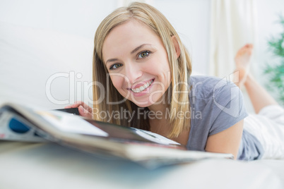 Portrait of casual woman with magazine lying on couch Portrait of casual woman with magazine lying on couch