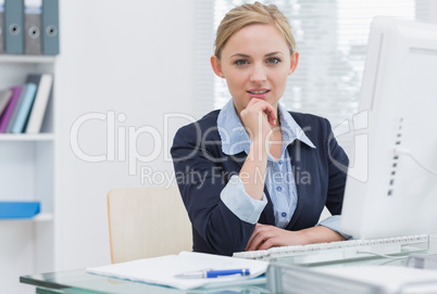 Confident business woman with computer at office desk