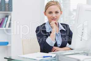 Confident business woman with computer at office desk