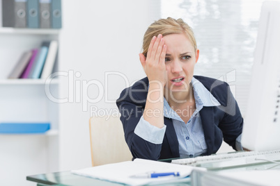 Displeased business woman at office desk