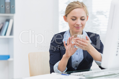 Business woman text messaging at office desk