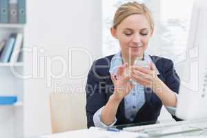 Business woman text messaging at office desk