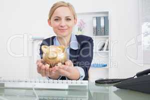 Portrait of business woman with golden piggy bank at office