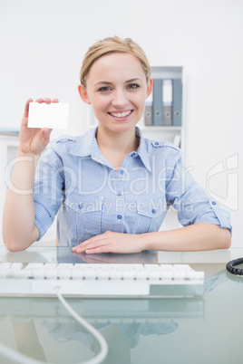 Portrait of female executive holding blank card at office