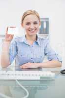 Portrait of female executive holding blank card at office