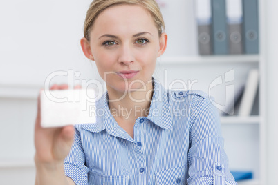 Female executive holding blank card at office