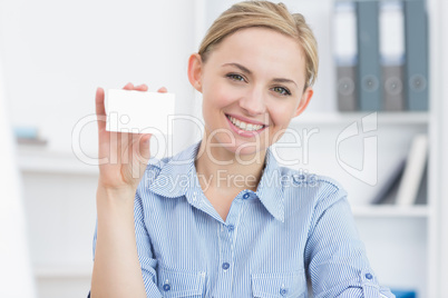 Female executive holding blank card at office