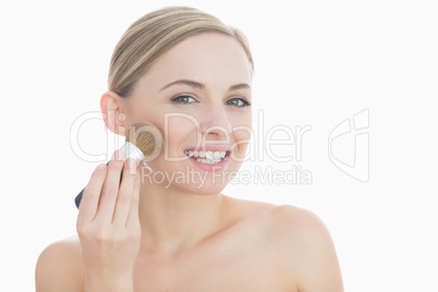 Portrait of smiling young woman putting on make-up