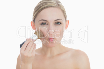 Portrait of young woman putting on make-up
