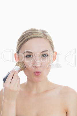 Portrait of young woman putting on make-up