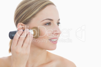 Close-up of young woman putting on make-up