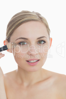 Close-up portrait of young woman putting on make-up Close-up portrait of young woman putting on make-up