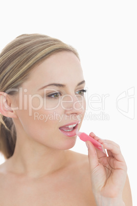 Close-up of young woman applying lipgloss