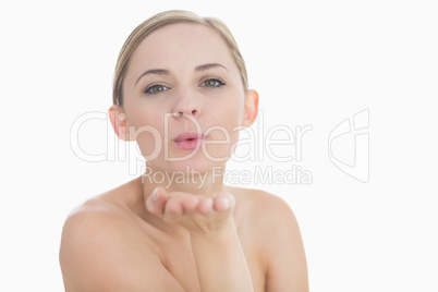 Close-up of cute young woman blowing a kiss