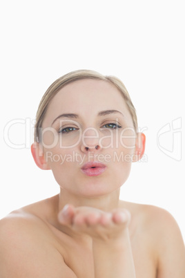 Close-up of cute young woman blowing a kiss