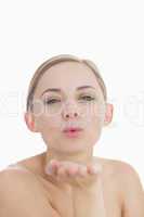 Close-up of cute young woman blowing a kiss