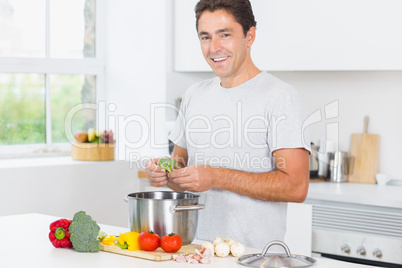 Smiling man making dinner