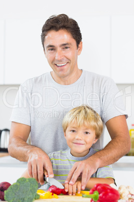 Father showing son how to slice vegtables