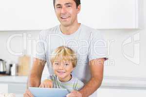 Happy father and son using tablet computer