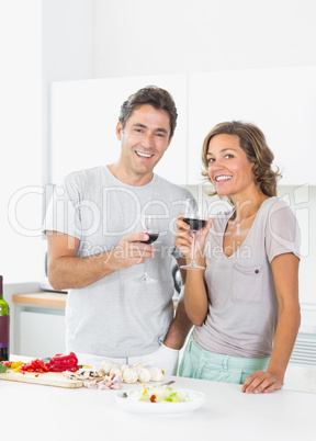 Couple drinking red wine and preparing salad