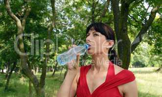 Young woman drinking water outdoors