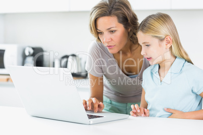 Mother and daughter using laptop