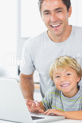 Happy son and father with laptop