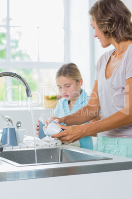 Mother and daughter doing the washing up