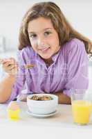 Young girl having cereal for breakfast