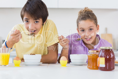 Siblings eating cereal for breakfast