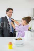 Daughter fixing fathers tie