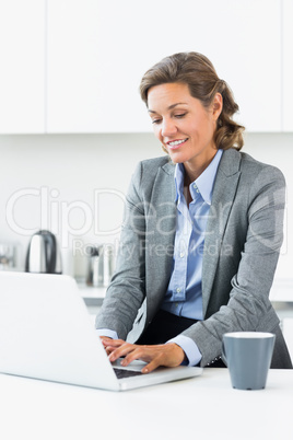 Happy woman typing on laptop