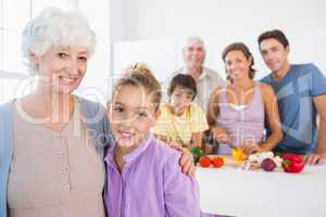 Grandmother and granddaughter standing beside counter