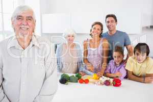 Happy grandfather standing by kitchen counter