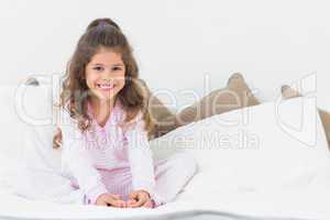 Cute girl sitting on bed