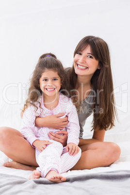 Mother and daughter sitting on bed Mother and daughter sitting on bed