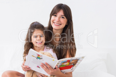Happy mother and daughter with storybook
