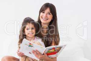 Happy mother and daughter with storybook