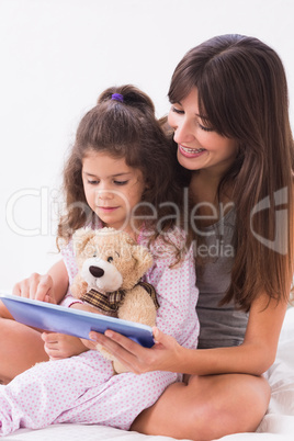 Smiling mother and daughter using tablet computer